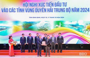 Chủ tịch UBND tỉnh Phạm Anh Tuấn trao quyết định chủ trương đầu tư dự án Nhà máy sản xuất viên nén sinh học và chế biến vật liệu gỗ nội thất cho đại diện Công ty TNHH MTV Đầu tư và Phát triển kho bãi Nhơn Tân. Ảnh: N.DŨNG