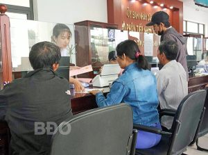 Người dân làm hồ sơ, thủ tục về đất đai tại bộ phận một cửa của UBND TX An Nhơn. Ảnh: V.L